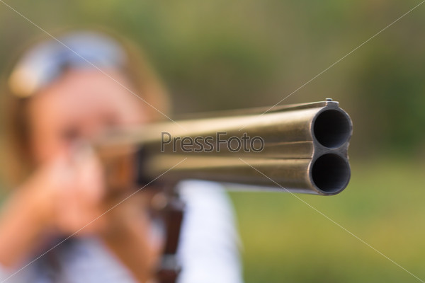 A young girl with a gun for trap shooting, stock photo