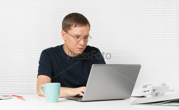 young man working with laptop at his desk