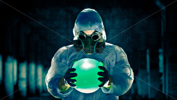 man in protective costume and respirator holding danger ball