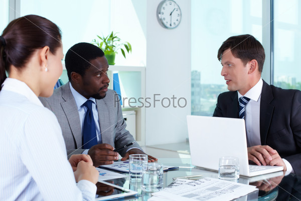 Portrait of business team discussing documents at meeting