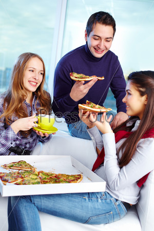 Image of teenage friends eating pizza together
