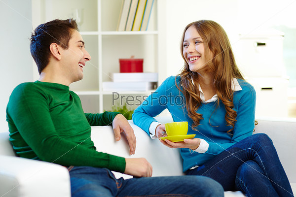 Portrait of joyful friends looking at one another while chatting
