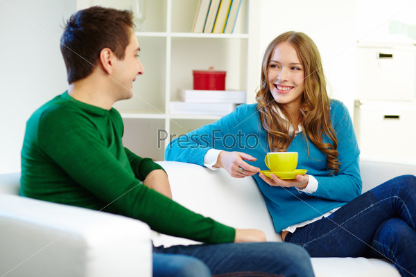 Portrait of joyful friends chatting at home