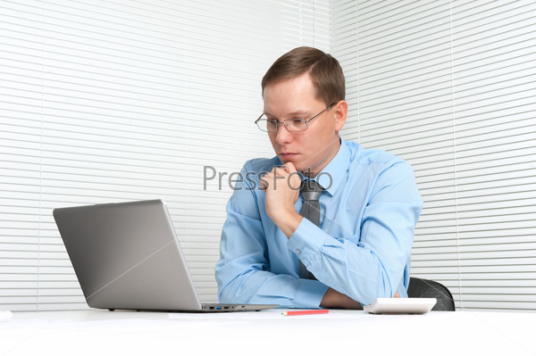 worried businessman sitting at desk with laptop