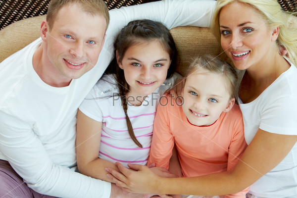 Portrait of happy family with two children sitting at home