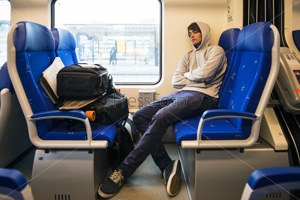 Молодой человек спит в поезде