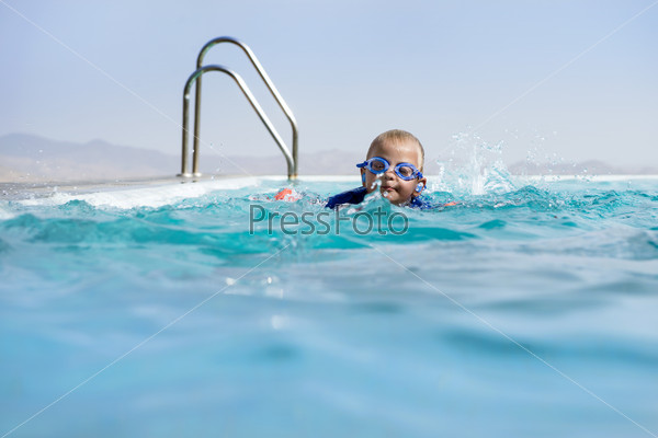 Boy Swimming In an Infinity Pool Wearing Swimming Goggles