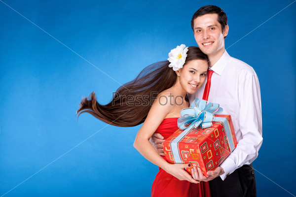 guy with girl are holding box with gift