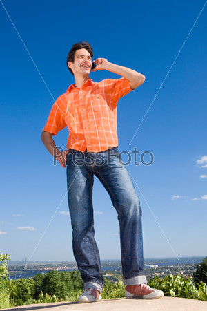 Young man from the phone calls. It was on Mount. Against a blue sky with clouds