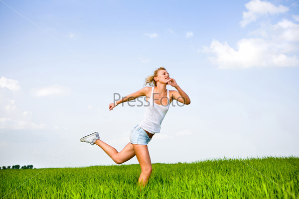 Happy girl is running in a field