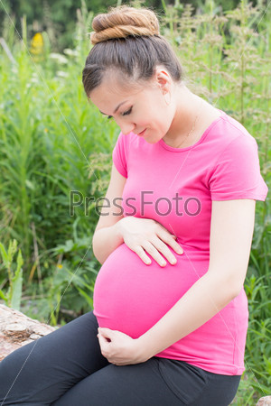 happy pregnant woman with big belly rest on nature