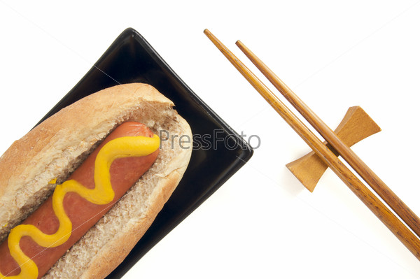 East Meets West - Hot Dog and Chopsticks Isolated on a White Background.