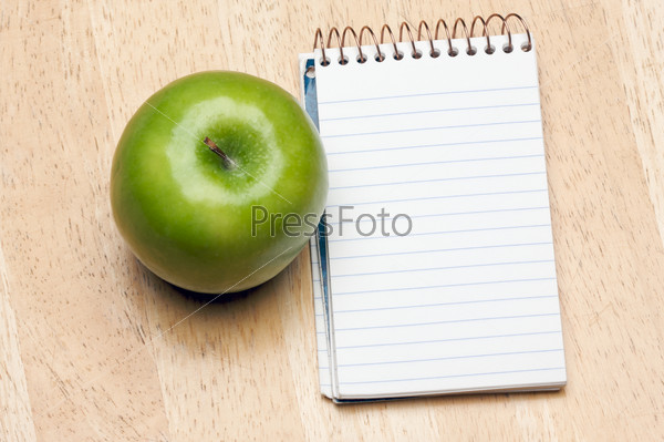 Pad of Paper and Apple on a Wood Background, stock photo