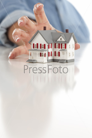 Womans Hand Reaching for Model House on White