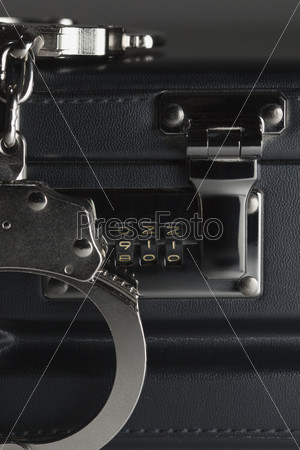 Pair of Handcuffs on Briefcase with the Numbers 911 on Lock, stock photo
