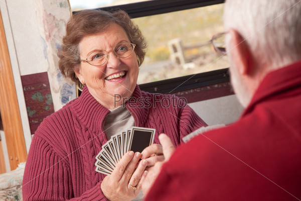 Пожилая семейная пара играют в карты
