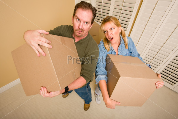Obviously Exhausted Couple Holding Moving Boxes in Empty Room, stock photo