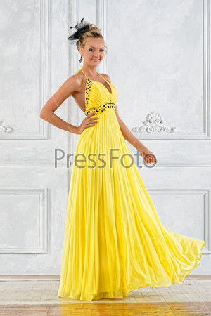 Beautiful blonde woman in a long yellow dress.