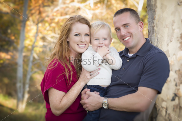 Young Attractive Parents and Child Portrait Outdoors.