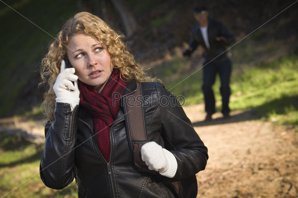 Pretty Young Teen Girl Calling on Cell Phone with Mysterious Strange Man Lurking Behind Her.