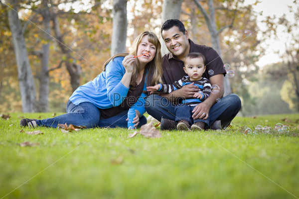Happy Young Mixed Race Ethnic Family Playing Together with Bubbles In The Park, stock photo