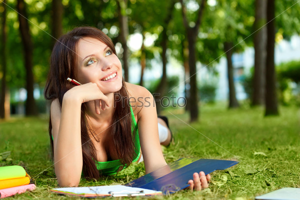 dreaming woman laying on grass in park