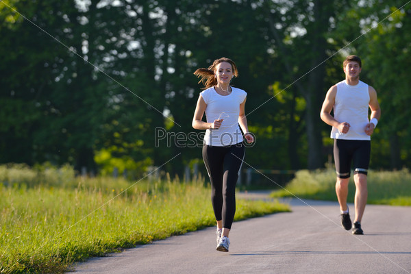 Young couple jogging in park at morning. Health and\
fitness.