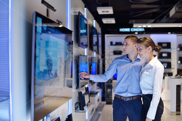 People in consumer electronics retail store looking at latest laptop, television and photo camera to buy, stock photo