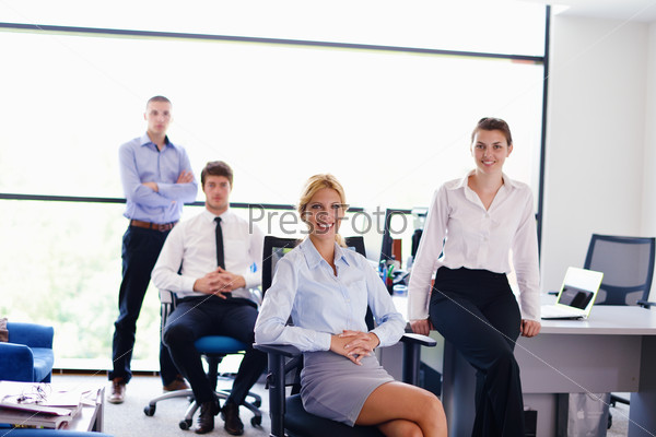 business woman with her staff in background at office