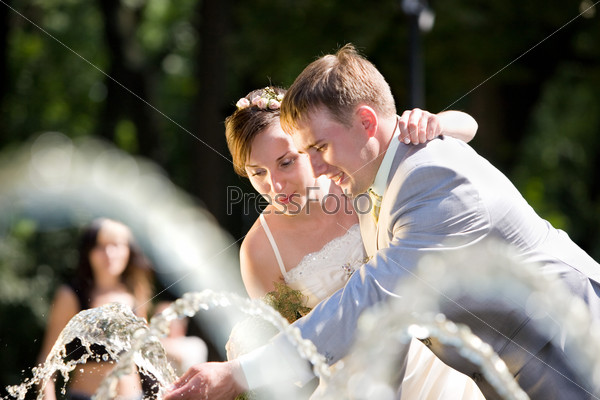 Groom and bride joy in fountain