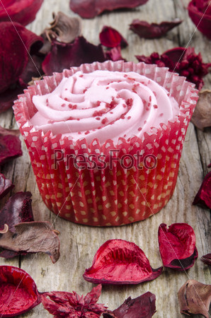 strawberry cupcake with pink shimmer sugar on a timber board