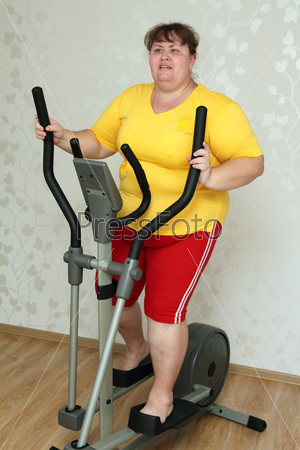 Overweight woman exercising on trainer