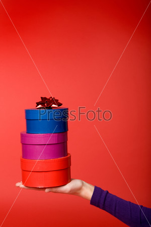 A stack of three gifts isolated on red with room for copy space