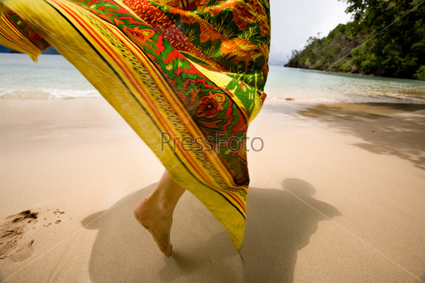 A woman\'s skirt blowing in the wind on a tropical beach
