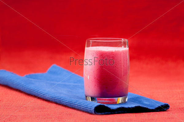 A red berry smoothie isolated on blue and red