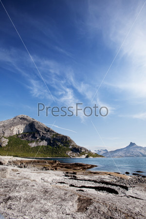 A coastal landscape in northern norway with a mountain and rock