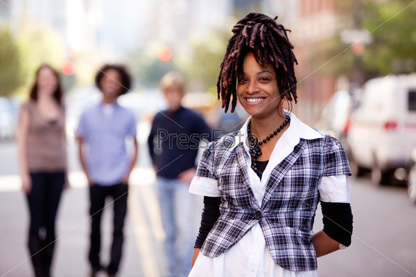 A pretty African American woman in the city with friends