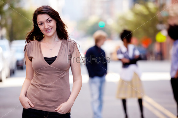 A woman in a city setting with friends in the background