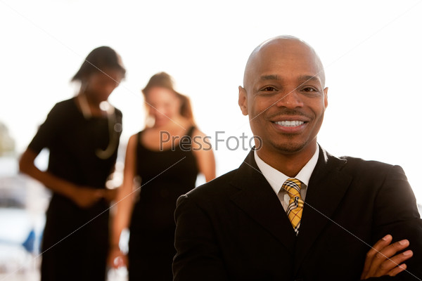 An african american business man with colleagues in the background