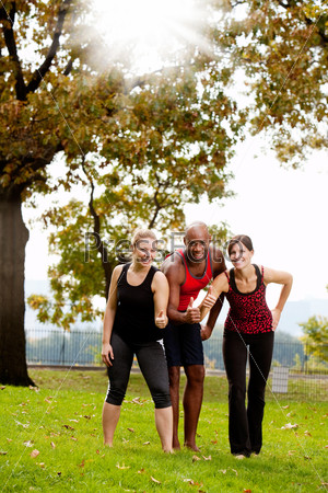 A group of friends exercising in the park - giving the thumbs up