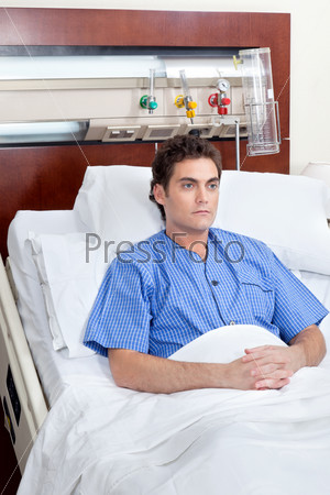 Serious patient sitting on bed in hospital