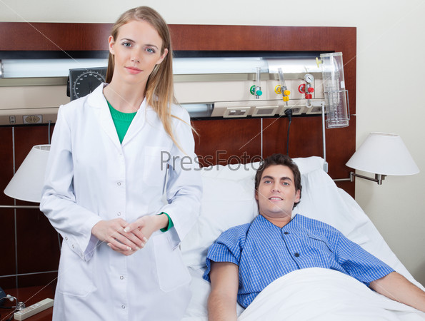 Portrait of confident young female doctor with patient in hospital