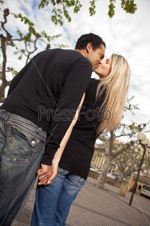 A couple in an urban European city setting kissing