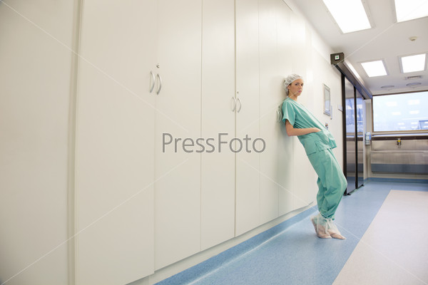 Young female doctor or nurse standing in hospital corridor