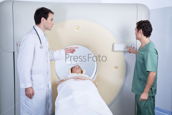 Doctor giving instructions to technician for carrying out MRI scan