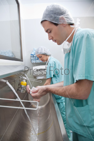 Doctors washing hands after operation