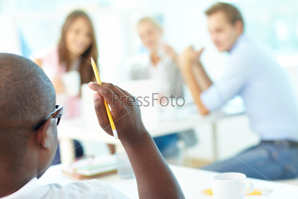 Rear view of African guy holding pencil with group of students looking at him