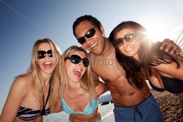 A group of crazy friends on the beach having fun