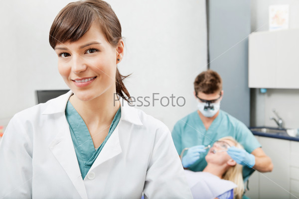 Portrait of a dental assistant smiling with dentistry work in the background