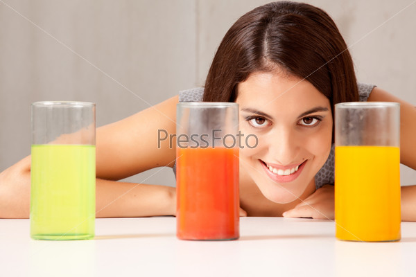 Three glasses with colorful liquid - woman doing experiement
